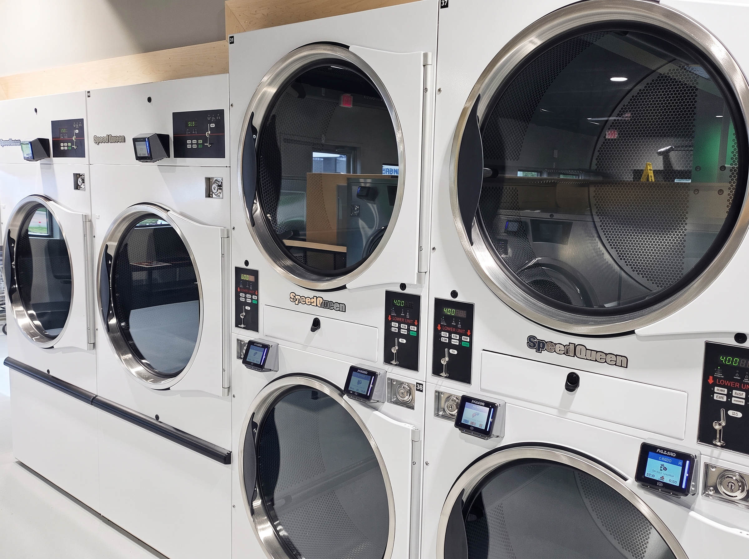 Stacked Speed Queen dryers with card readers
